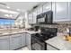 Modern kitchen featuring granite countertops, stainless steel appliances, and gray cabinetry at 13427 Blue Heron Beach Dr # 405, Orlando, FL 32821