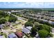 An aerial view shows a neighborhood with tree-lined streets, green spaces, and diverse housing styles at 4316 Natchez Trace Dr, St Cloud, FL 34769