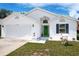 Inviting single-Gathering home featuring a two-car garage, well-kept lawn, and colorful front door at 4316 Natchez Trace Dr, St Cloud, FL 34769