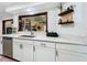 Modern kitchen featuring white cabinets, stainless steel appliances, and a unique pass-through window to the living area at 4316 Natchez Trace Dr, St Cloud, FL 34769