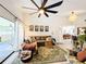 Comfortable living room with eclectic decor, large ceiling fan, and sliding glass door to the patio at 4316 Natchez Trace Dr, St Cloud, FL 34769