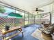 Enclosed porch features seating, an umbrella, and a peaceful view of the yard at 4316 Natchez Trace Dr, St Cloud, FL 34769