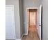 Hallway featuring gray paint, wood floors, and multiple open doorways at 3224 Dante Dr # 108, Orlando, FL 32835