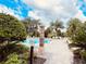 Community pool surrounded by lush landscaping and blue skies at 3224 Dante Dr # 108, Orlando, FL 32835