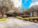 Tree lined street and landscaping leads to multi-unit homes under a bright sky at 3224 Dante Dr # 108, Orlando, FL 32835