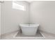 Modern freestanding bathtub with tile surround and a window to let in natural light at 13455 Sw 85 Pl, Dunnellon, FL 34432