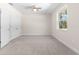 Well-lit bedroom with carpet flooring, double door closet, ceiling fan, and a window view at 13455 Sw 85 Pl, Dunnellon, FL 34432
