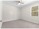 A bright bedroom featuring neutral walls, carpet flooring, a ceiling fan, and a window at 13455 Sw 85 Pl, Dunnellon, FL 34432
