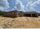 New construction exterior featuring concrete walls, attached two car garage, and a covered front entry way at 13455 Sw 85 Pl, Dunnellon, FL 34432