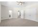 Spacious main bedroom with plush carpet, ceiling fan, and multiple entrances at 13455 Sw 85 Pl, Dunnellon, FL 34432