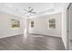 Spacious main bedroom with multiple windows, tray ceiling, ceiling fan, and light gray flooring at 13455 Sw 85 Pl, Dunnellon, FL 34432