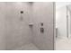 Walk-in shower with gray tile, rainfall shower head, and a built-in shelf at 13455 Sw 85 Pl, Dunnellon, FL 34432