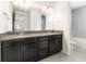 Bathroom featuring a double granite vanity, gray floor tiles, and a shower tub with white tiles at 10266 Beechwood Ln, Orlando, FL 32832