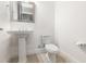 Powder room with a pedestal sink, modern fixtures, and a toilet at 10266 Beechwood Ln, Orlando, FL 32832