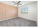 Bedroom with a stylish accent wall, plush carpet, ceiling fan, and a bright window at 10266 Beechwood Ln, Orlando, FL 32832