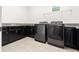 Laundry room with front loading washer and dryer units and dark cabinetry with countertop at 10266 Beechwood Ln, Orlando, FL 32832