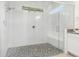 Modern glass-enclosed shower with pebble floor and white subway tile at 10266 Beechwood Ln, Orlando, FL 32832