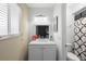 Bright bathroom featuring a white vanity with a sleek countertop, modern lighting fixture, and shower at 2495 Sedgefield Ave, Deltona, FL 32725