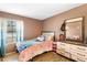 Comfortable bedroom with a window letting in natural light, dresser, and bed at 2495 Sedgefield Ave, Deltona, FL 32725