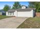 Single-story home with a two car garage, white siding, black shutters and a gray roof at 2495 Sedgefield Ave, Deltona, FL 32725