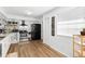 Bright kitchen featuring white cabinets, stainless steel appliances, modern decor, and wood-style flooring at 2495 Sedgefield Ave, Deltona, FL 32725
