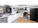 Well-lit kitchen with stainless steel appliances, white cabinets, and wood floors at 2495 Sedgefield Ave, Deltona, FL 32725