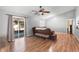 Bright living room with wood floors, slider door, and stylish media cabinet at 2495 Sedgefield Ave, Deltona, FL 32725