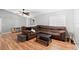 Spacious living room with wood floors, a large brown sectional, and natural light at 2495 Sedgefield Ave, Deltona, FL 32725