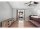 Bright living room with wood floors, slider door, and stylish media cabinet at 2495 Sedgefield Ave, Deltona, FL 32725