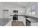 Bright kitchen featuring white cabinets, stainless steel appliances, granite countertops, and modern fixtures at 5577 Creek Haven Way, Lakeland, FL 33810