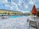 Community pool with lounge chairs and patio tables at 9825 Red Eagle Dr, Orlando, FL 32825