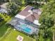 Aerial view of a home with a screened-in pool, tile roof, and well-maintained backyard at 1306 Sweetwater Club Blvd, Longwood, FL 32779