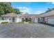 Home exterior featuring a tile roof, arched windows, circular driveway and lush landscaping at 1306 Sweetwater Club Blvd, Longwood, FL 32779