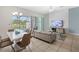 Open concept dining area with white table and modern chairs, overlooking the pool at 154 Captiva Dr, Davenport, FL 33896