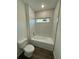 Bathroom with white tile tub and toilet at 29 W 17Th St, Apopka, FL 32703