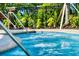 Inviting community hot tub with vibrant blue tile, steel handrail, and lush landscaping at 4114 Breakview Dr # 406, Orlando, FL 32819