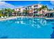 Beautiful large community pool with abundant deck seating and umbrellas, surrounded by apartments and palm trees at 4114 Breakview Dr # 406, Orlando, FL 32819