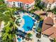 Aerial view of a large, sparkling blue swimming pool with ample lounge seating and lush landscaping near apartment buildings at 4114 Breakview Dr # 406, Orlando, FL 32819