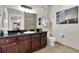 Beautiful bathroom with dark wood cabinets, granite counters, and a large framed mirror at 1301 Tuscan Ter # 9303, Davenport, FL 33896