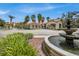 Community entrance with lush landscaping, a fountain, and a guard house at 1301 Tuscan Ter # 9303, Davenport, FL 33896