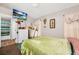 Inviting bedroom featuring a soft green comforter and a mounted TV at 5003 Aventura Blvd, Orlando, FL 32839