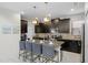 Modern kitchen with dark cabinetry, granite countertops, and an island with seating at 5431 Solterra Cir, Davenport, FL 33837