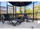 Screened patio with comfortable lounge chairs and umbrella at 5431 Solterra Cir, Davenport, FL 33837