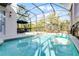 Inviting pool area with screened enclosure, lounge chairs, and floating devices at 5431 Solterra Cir, Davenport, FL 33837