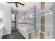 Bright bathroom featuring a glass enclosed walk-in shower and a soaking tub, neutral tile work and dark wood floors at 290 Silver Maple Rd, Groveland, FL 34736
