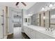 En suite bathroom with double vanity, large mirror, walk-in shower, and doorway to the main bedroom area at 290 Silver Maple Rd, Groveland, FL 34736