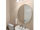 Half bath featuring a round mirror above a modern sink and toilet at 290 Silver Maple Rd, Groveland, FL 34736