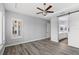 A well-lit primary bedroom features wood floors, a tray ceiling with a ceiling fan, and access to a primary bath at 290 Silver Maple Rd, Groveland, FL 34736
