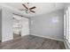 A primary bedroom boasts wood floors, a ceiling fan, and a sliding barn door leading into the primary bath at 290 Silver Maple Rd, Groveland, FL 34736