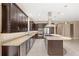 This kitchen boasts granite countertops, dark cabinetry, an island with seating, and stainless steel appliances at 290 Silver Maple Rd, Groveland, FL 34736
